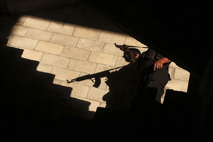 24 hours in pictures: Gaza City, Gaza: A Hamas member stands guard during a rally