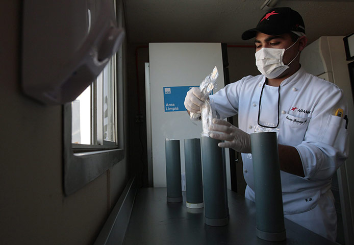 Trapped miners in Chile: 9 September: A member of a rescue team loads delivery tubes called palomas