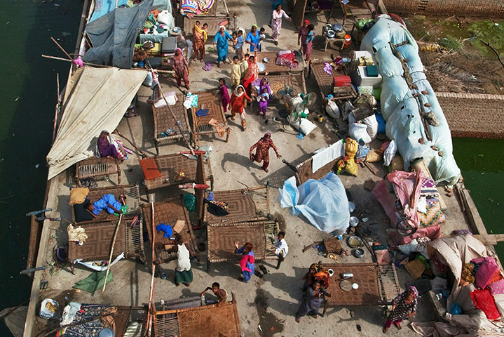 Six weeks later: Pakistan: Flood victims, trapped on a roof top, scramble for food rations