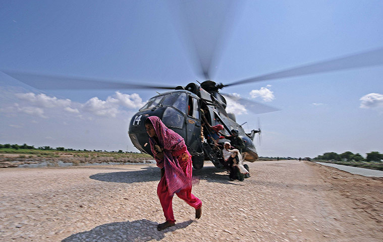 Six weeks later: Pakistan: A flood victim leaves a rescue helicopte