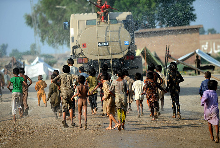 Six weeks later: Pakistan: Internally displaced Pakistani children chase a truck