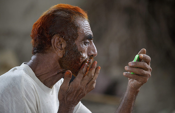 24 hours in pictures: Flood victim applies henna dye to his beard and hair in Pakistan