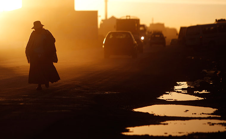 24 hours in pictures: A woman walks along the street at sunset in El Alto, Bolivia