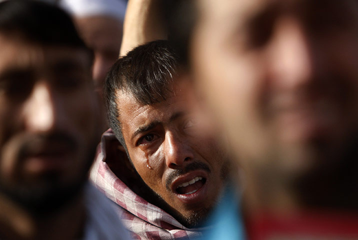 A man cries as he hears of the desecration of a Quran