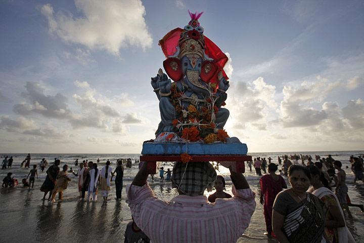 24 hours: Mumbai, India: A devotee carries an idol of Hindu elephant god Ganesh