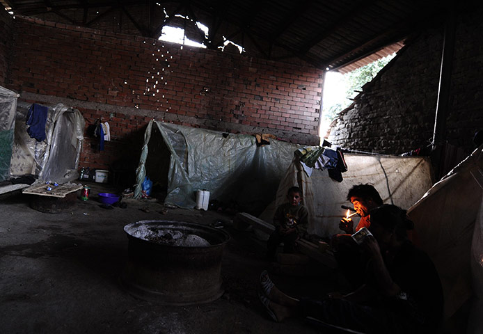 24 hours: Negotino, Macdeonia: A member of a Roma family lights a cigarette