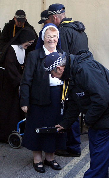 Pope Day 2: A nun is checked by police as she passes through a security checkpoint
