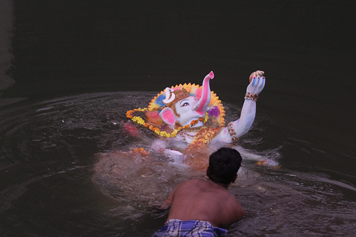 24 hours in pictures: A man immerses an idol of the Hindu god Ganesh in the Sabarmati river 