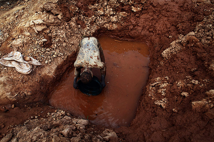 24 Hours in Pictures: A muddied prospector pans for gold in Manica Province