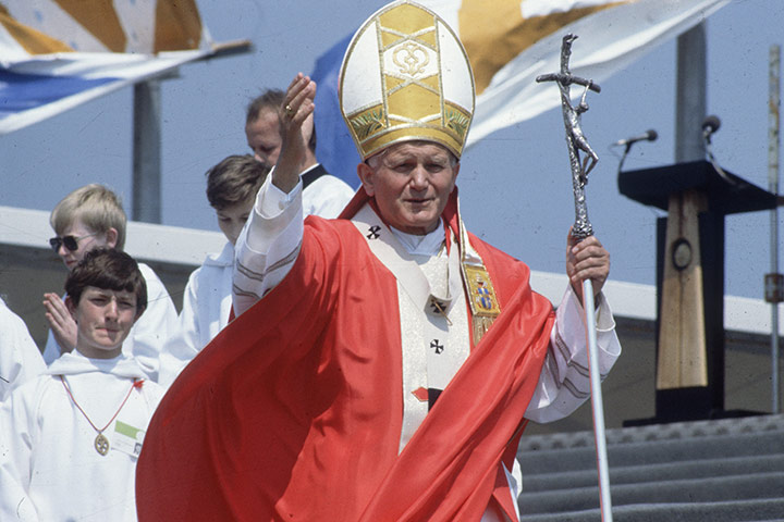 Pope 1982 Visit: Pope John Paul II stands with arm upraised during a visit to England