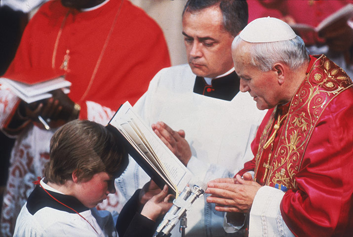 Pope 1982 Visit: Pope John Paul II reads from a book held by a choirboy