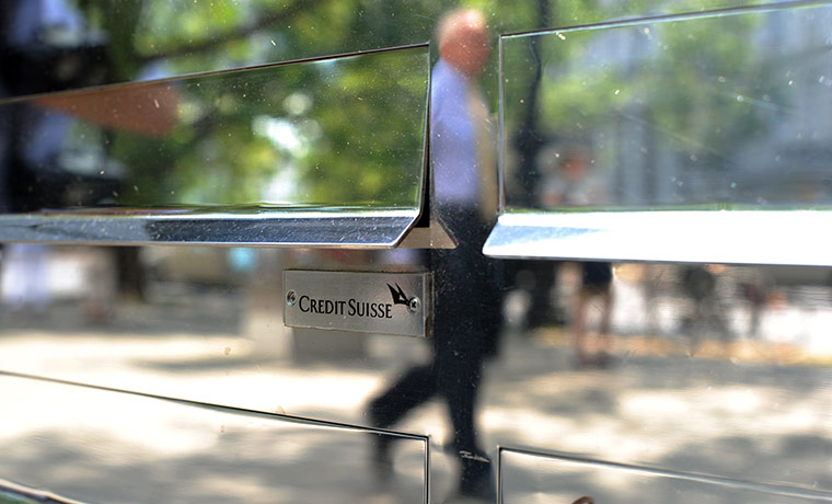 Week in business: A man walks past the logo of Swiss bank Credit Suisse in Berlin