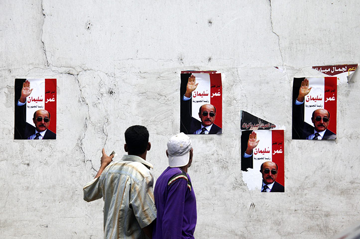 24 hours: Giza, Egypt: Egyptians walk by posters supporting Omar Suleiman