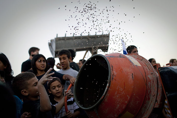 24 hours: Adam, West Bank: Jewish children throw material into a cement mixer