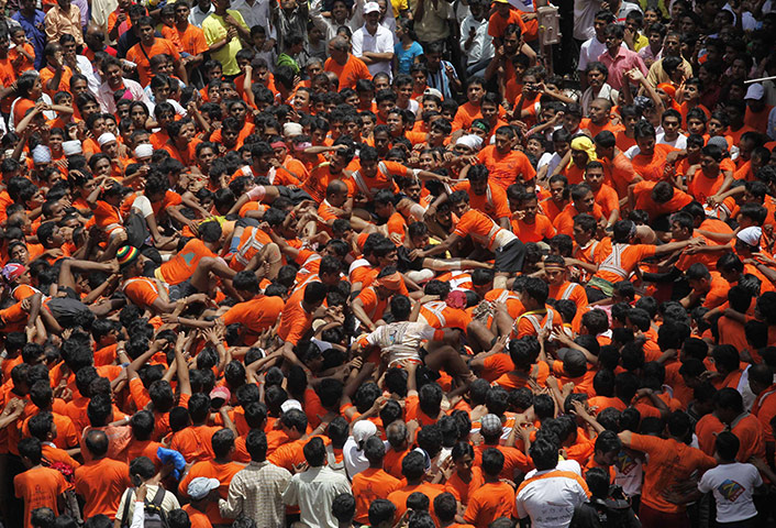 24 hours: Mumbai, India: Devotees take a tumble as they try to make human pyramid