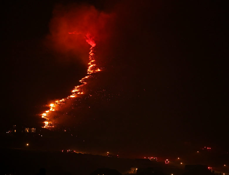 A wall of flames approaches homes in Herriman, Utah 