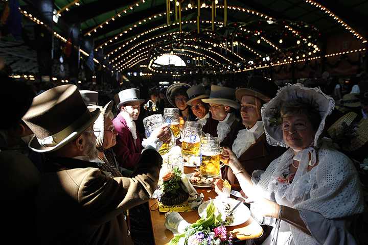 Oktoberfest in Munich: Visitors wearing historical dress drink beer and eat during the second day