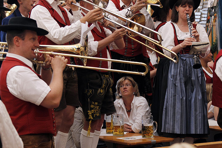 Oktoberfest in Munich: A woman sits as musicians play during the second day 