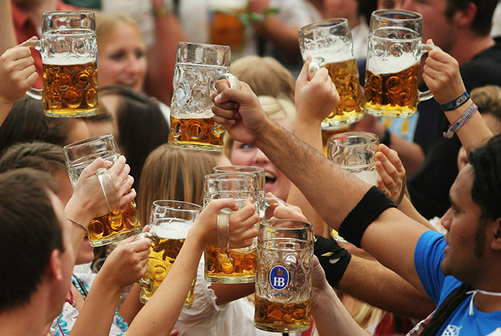 Oktoberfest in Munich: Visitors toast with beer mugs during the opening day of the Oktoberfest