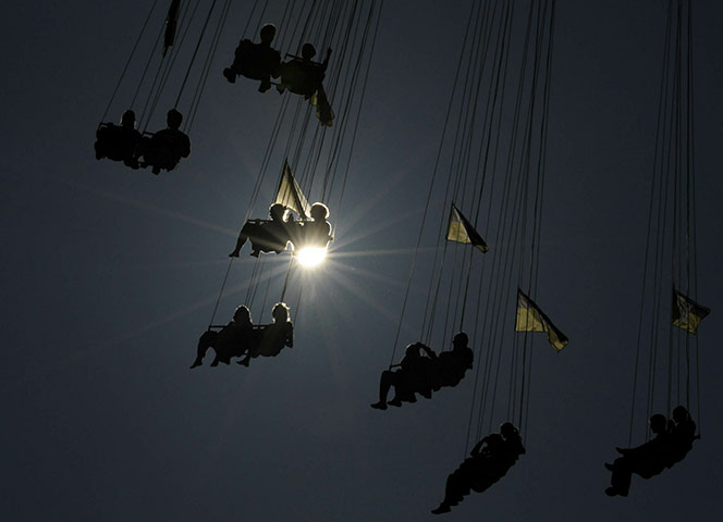 Oktoberfest in Munich: Visitors of the Oktoberfest beer festival sit in a chairoplane at the fair