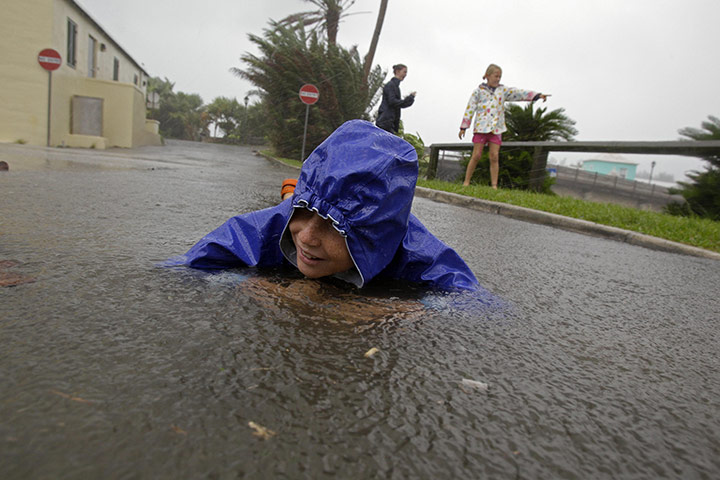 24 hours in pictures: Somerset Village, Bermuda: A boy lies in standing water as Hurricane Igor 