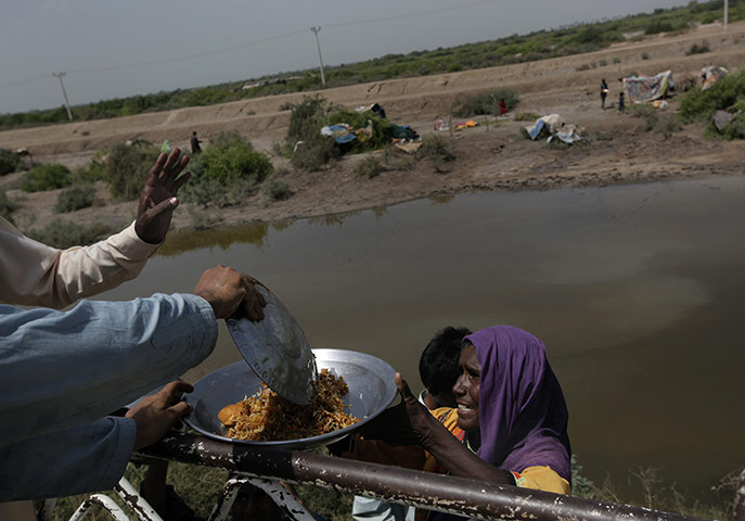 24 hours in pictures: food handout at temporary shelter for flood displace people in pakistan