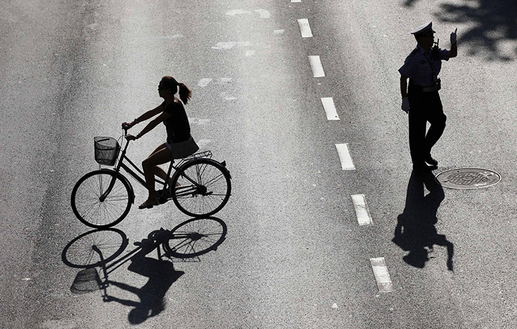 24 hours in pictures: a police officer directs traffic in Shanghai, China