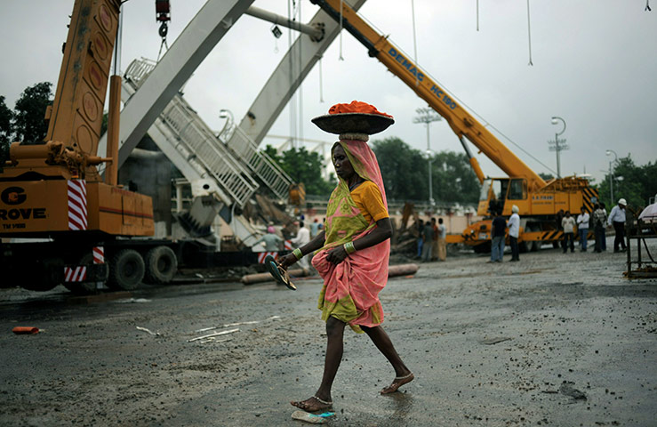 Commonwealth games: An Indian worker walks in front of a col