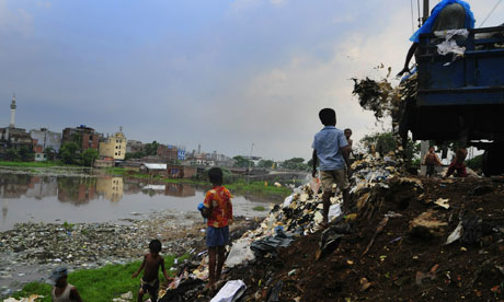 Bangladeshi children pick trash at a garbage dump