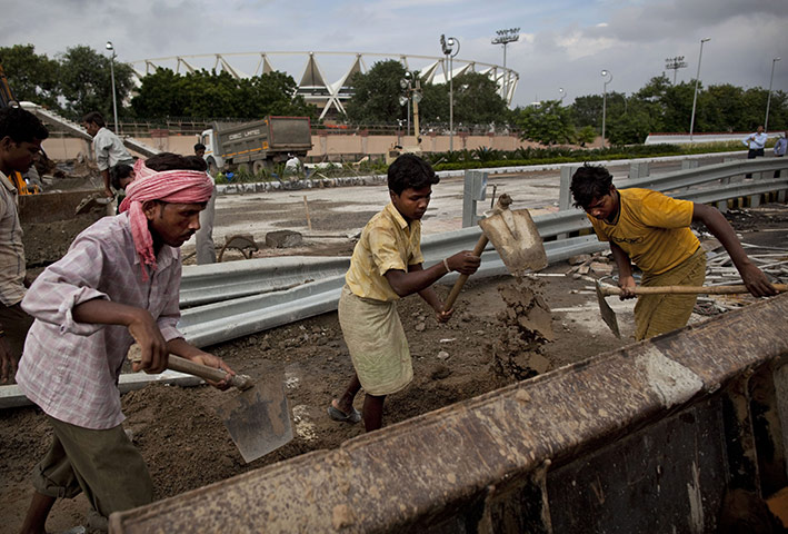 Commonwealth 2: Indian laborers working hard outside Jawaharlal  Nehru stadium. 