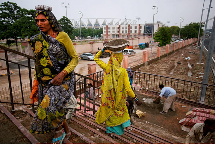 Commonwealth 2: Indian labourers work to concrete a staircase 