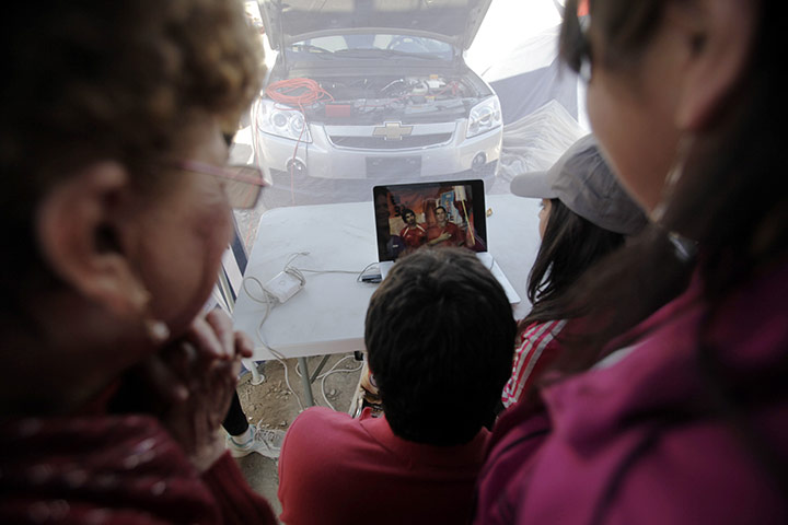 Trapped miners in Chile: September 18: Relatives of trapped miners watch a video of them