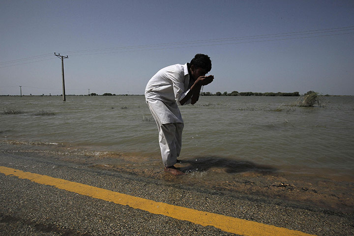 24 hours in pictures: Sujawal, Pakistan: A man washes his face in flood water