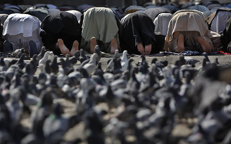 24 hours in pictures: Kabul, Afghanistan: Men pray in a street next to a  mosque