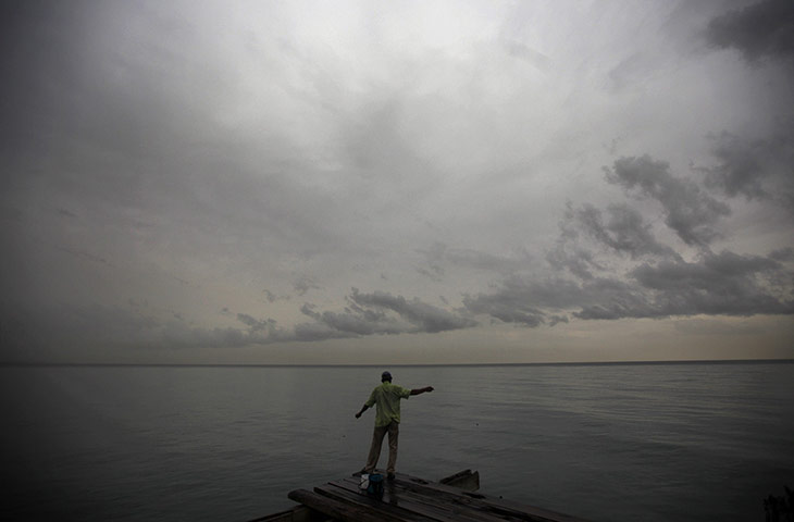 24 Hours: A man fishes off a bridge in La Ceiba, Honduras