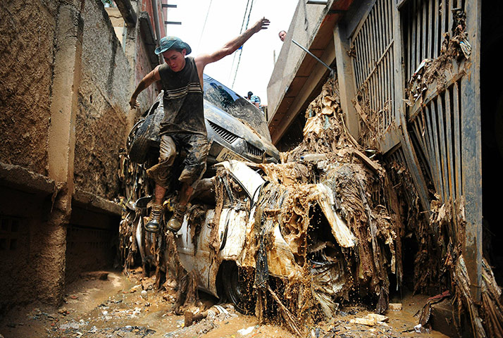 24 Hours: Caracas, Venezuela: A man jumps from stranded cars after heavy rains