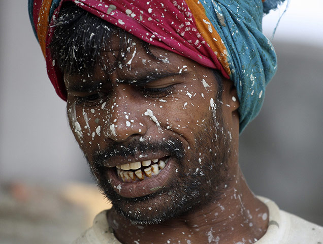 24 Hours: New Delhi, India: A labourer, with his face smeared with paint