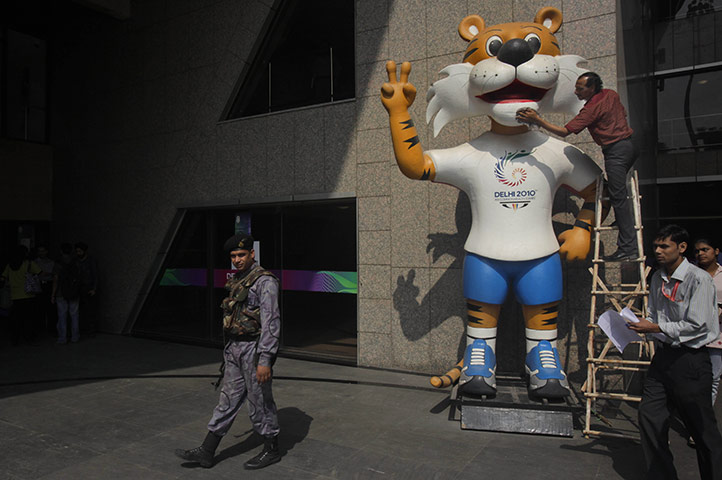 Commonwealth games: An Indian worker cleans the Commonwealth Games mascot Shera