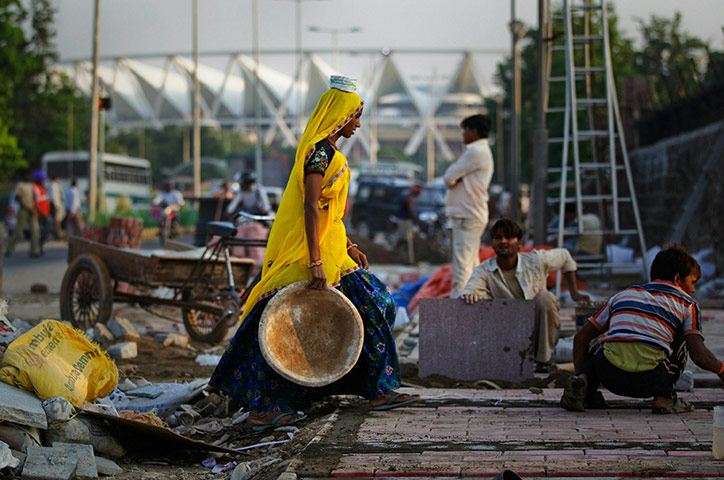 Commonwealth games: Indian labourers work in front of the Lawn Bowls venue 