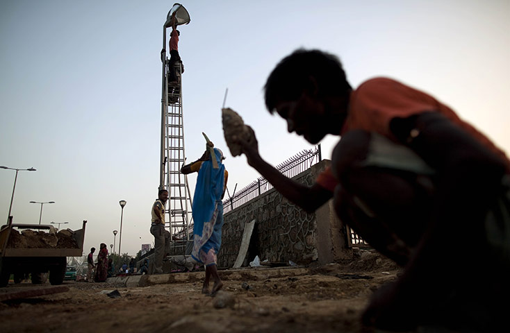 Commonwealth games: Labourers work at a construction site next to the lawn bowling venue 