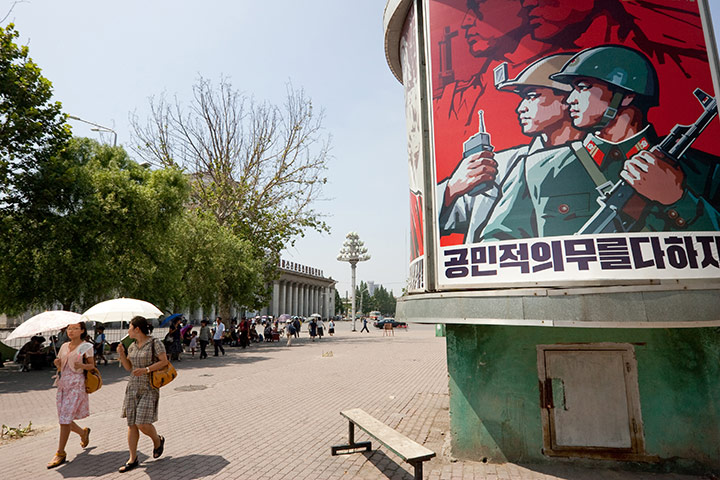 North Korea: Pyongyang street with one of North Korea's ubiquitous propaganda posters