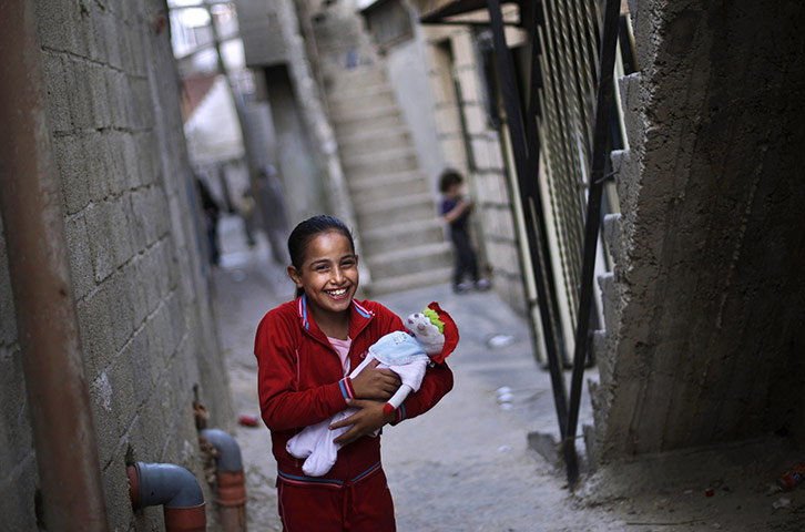Muhammed Muheisen: Palestinian Fatima, 10, laughs with a friend while playing