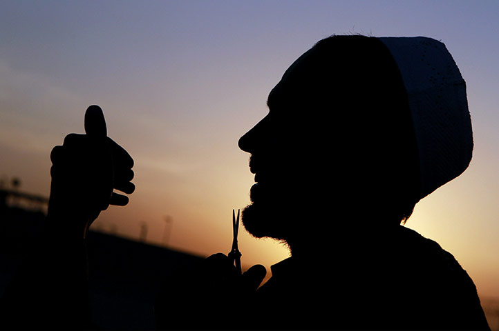 24 hours: Mazar-e-Sharif, Afghanistan: A man trimshis beard with a pair of scissors