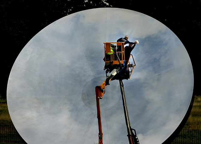 Kapoor: A worker cleans Anish Kapoor's sculpture Sky Mirror 