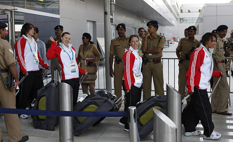 Commonwealth tues: Members of the England team walk past security personnel