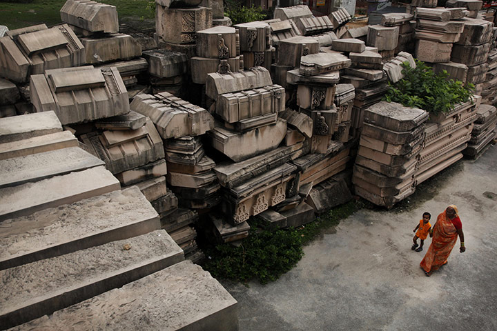 Ayodhya dispute: A Hindu woman walks past building blocks for a proposed Rama temple