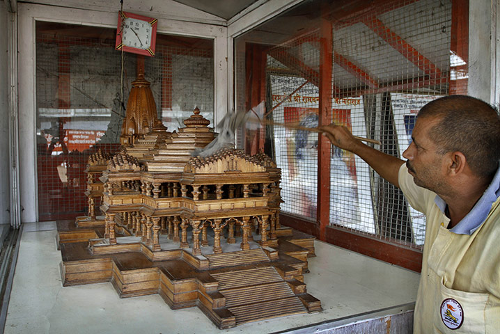 Ayodhya dispute: A worker dusts the model of a proposed Rama temple in Ayodhya