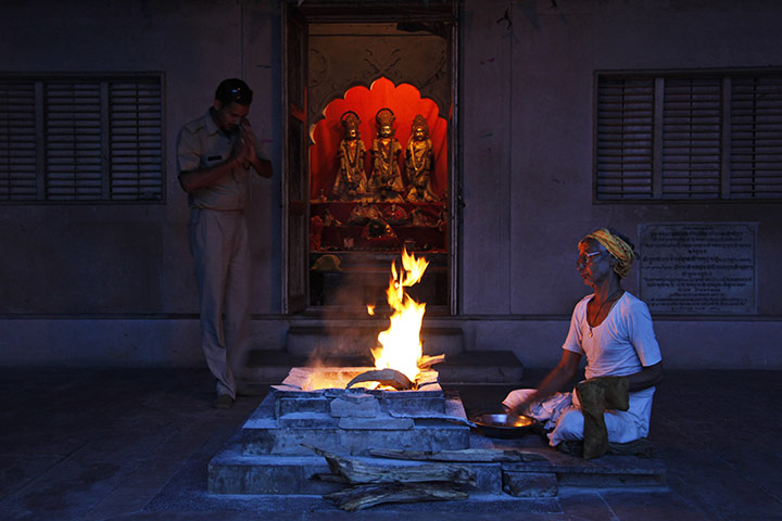 Ayodhya dispute: A police officer prays as a priest performs rituals at a small temple