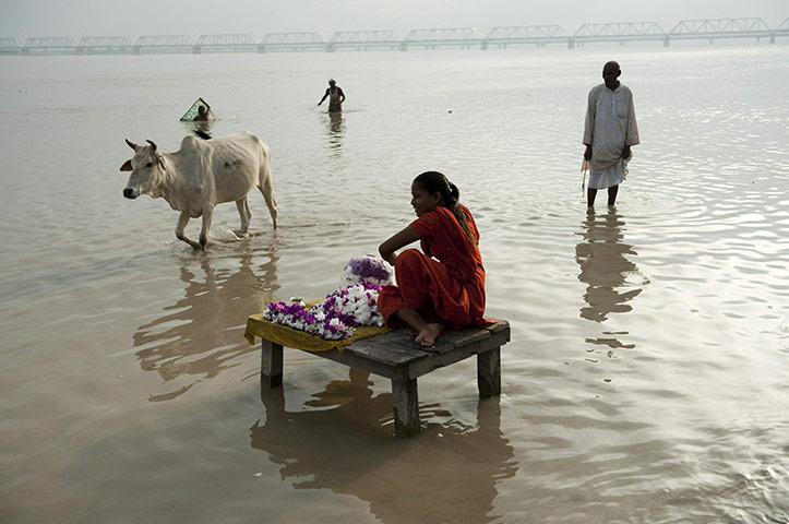 Ayodhya dispute: An Indian woman sells flowers to pilgrims on the banks of the Saryu river 