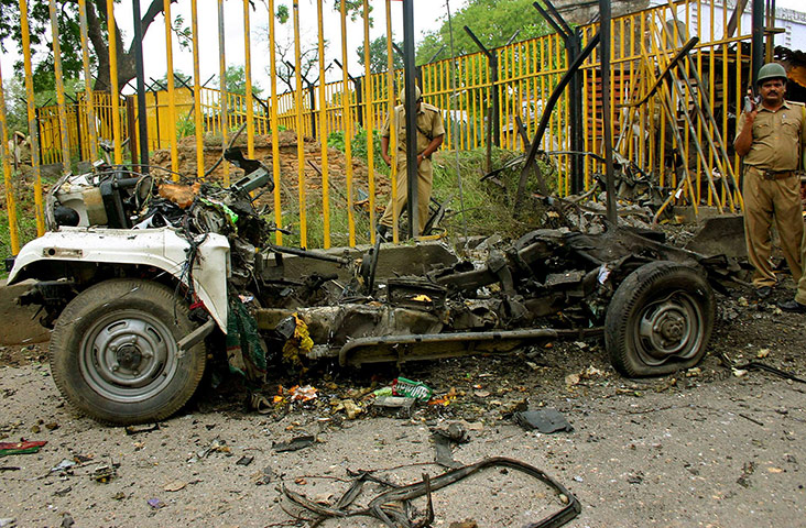 Ayodhya dispute: 5 July 2005: An Indian soldier stands guard near the wreckage of the jeep